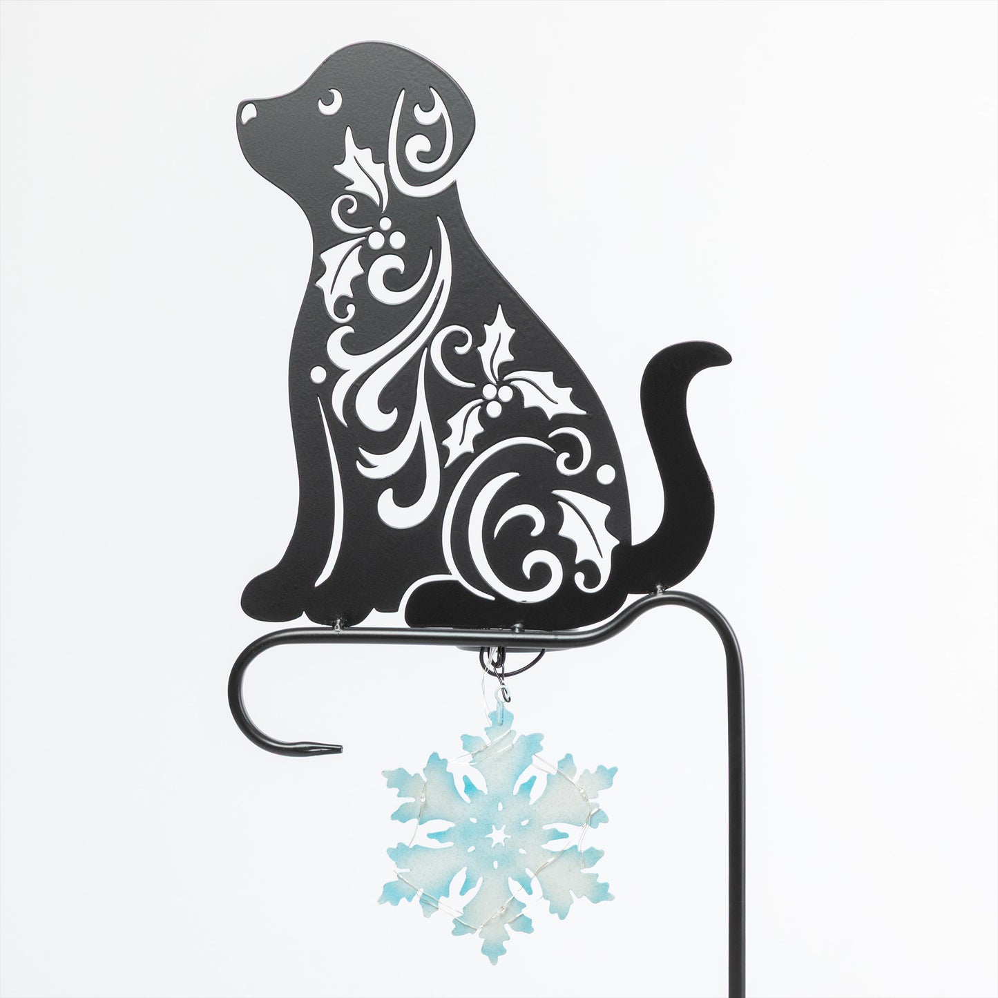 Decorative metal dog silhouette with floral patterns and a snowflake ornament on a white background