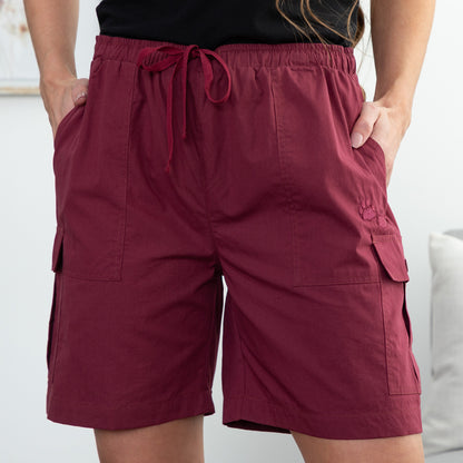 Maroon cargo shorts worn by a person on a white background