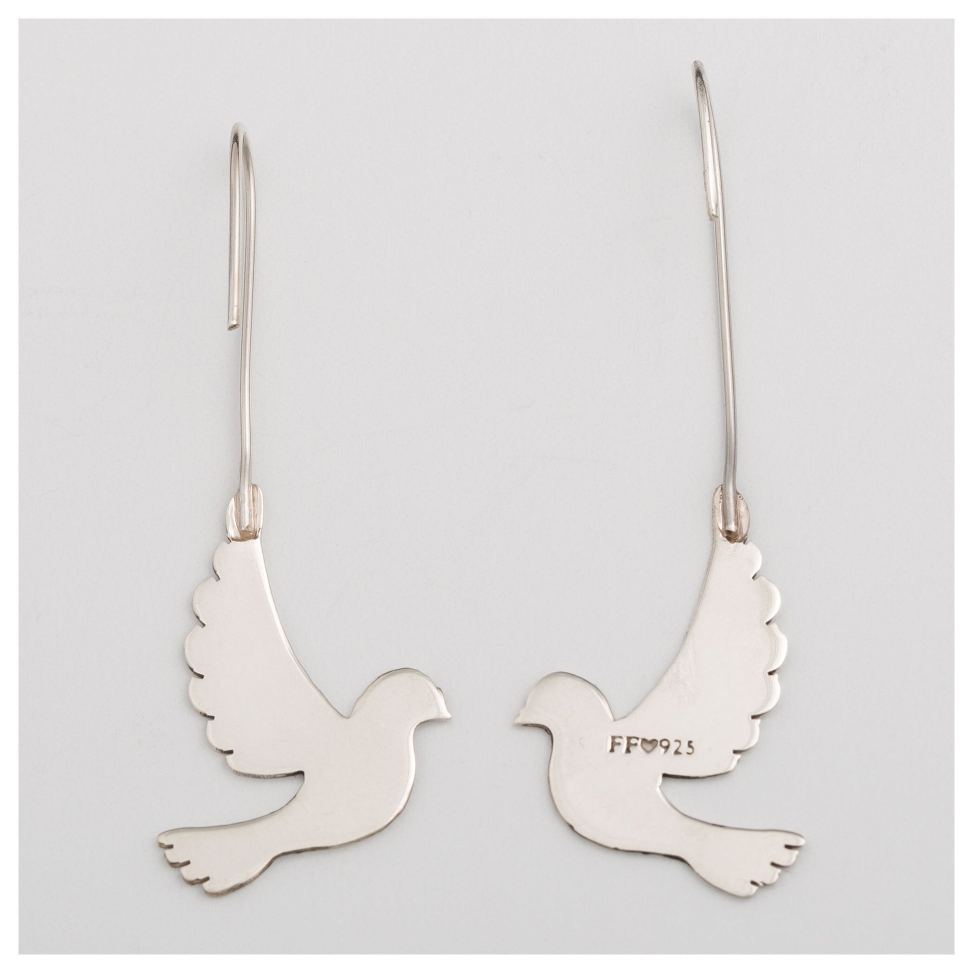 Back of silver dove-shaped earrings on a light gray background