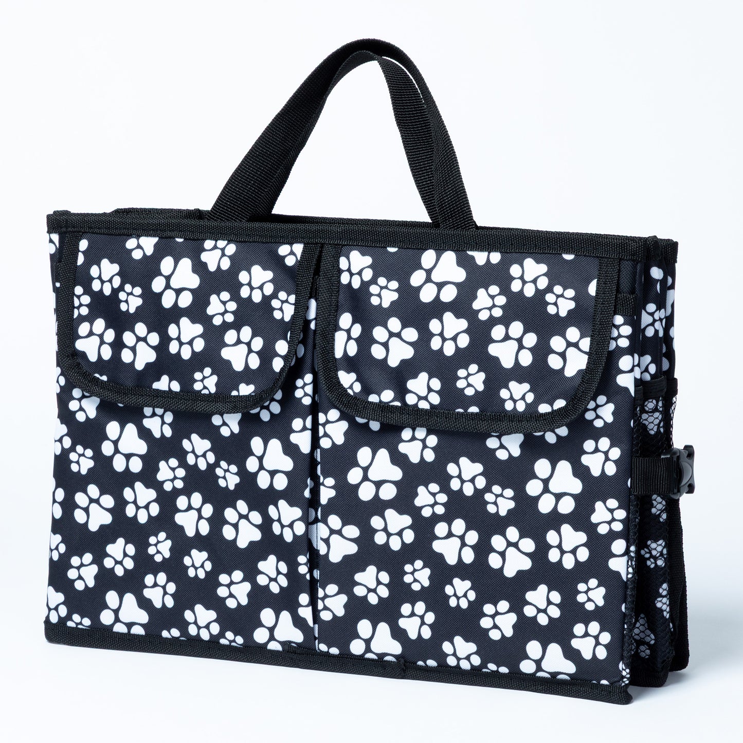 White paw print patterned car trunk organizer with pockets on the front, and a mesh pocket on the side, on a white background.