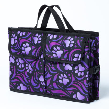 A paw print patterned car trunk organizer with pockets on the front, folded flat with a white background.