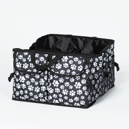 Many angles of a collapsible car trunk organizer, patterned in white paw prints on a white background. Video of the organizer being folded flat, then reopening.