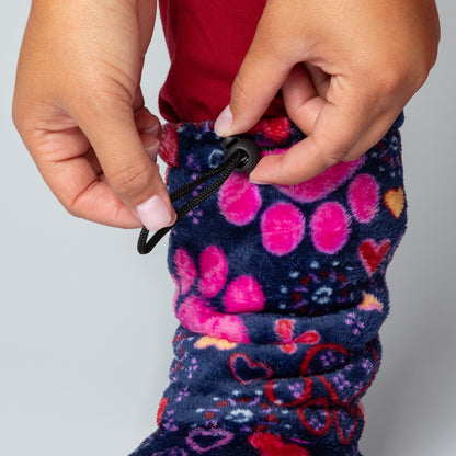 Close-up of a colorful patterned fabric with a toggle being pulled, on a plain background.