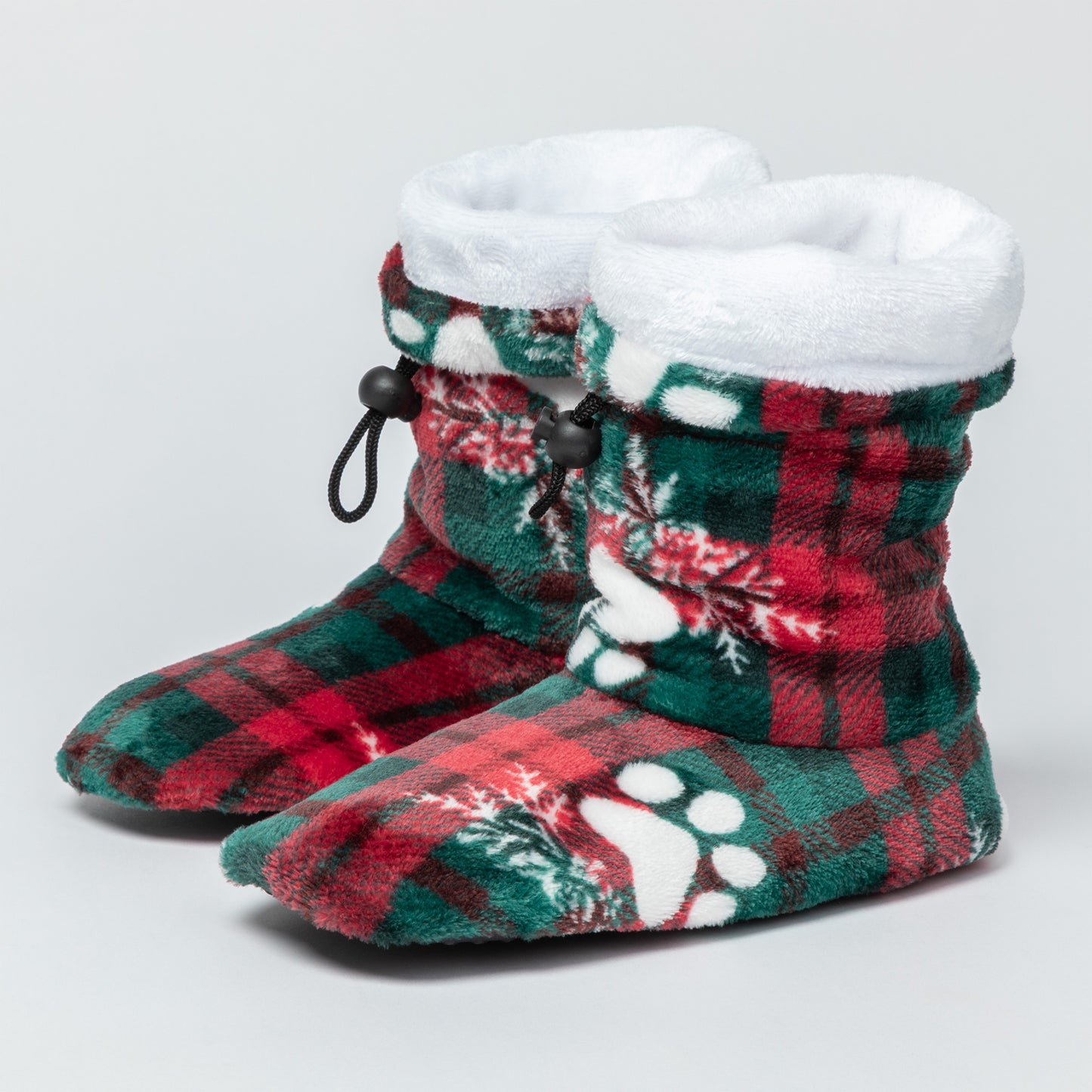 Red and green plaid slipper booties with paw prints and snowflakes, with white fleece lining, against a white background.