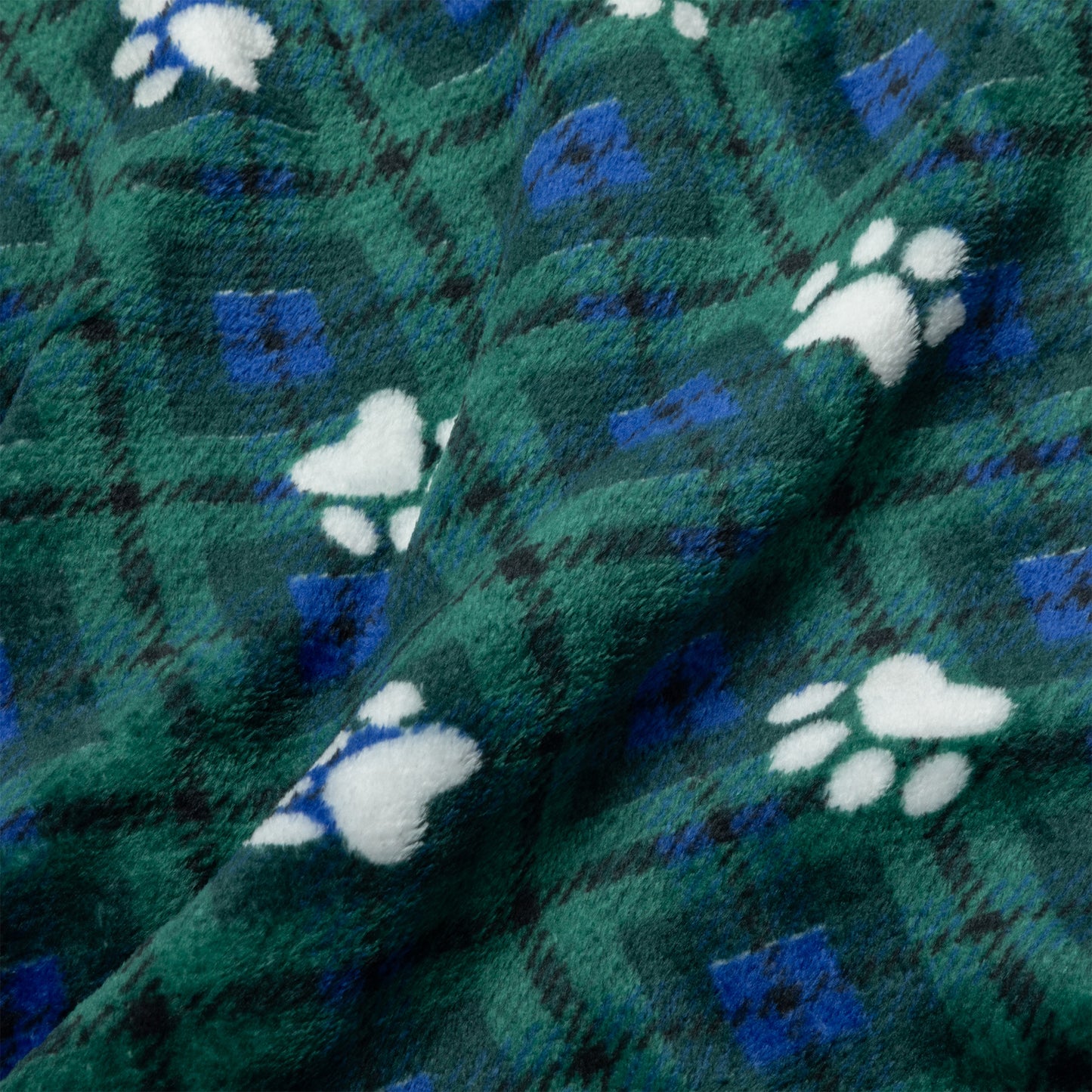 A close-up of a plush fleece blanket with a green and blue plaid pattern and white paw print motifs.