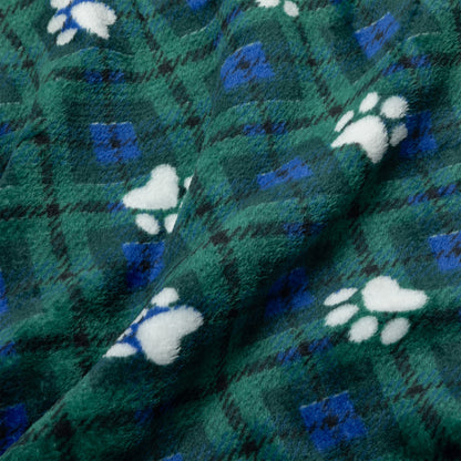 A close-up of a plush fleece blanket with a green and blue plaid pattern and white paw print motifs.