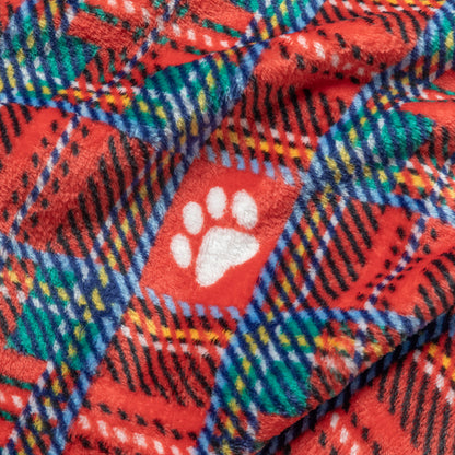 A close-up of a plush fleece blanket with a red and green plaid pattern, featuring a white paw print motif.