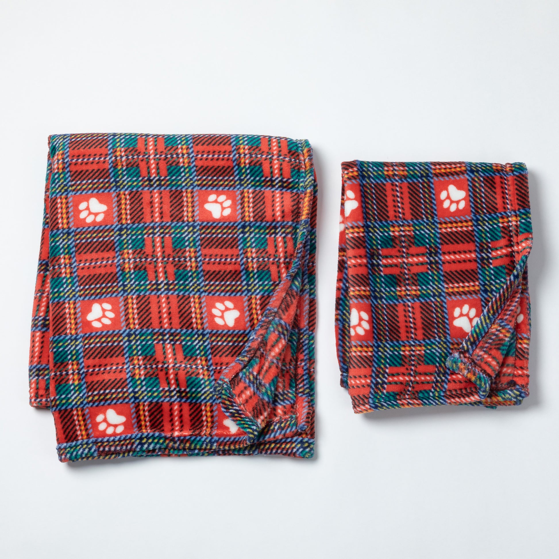 Two folded pet blankets in red plaid fabric with white paw print motifs, displayed on a light gray background.
