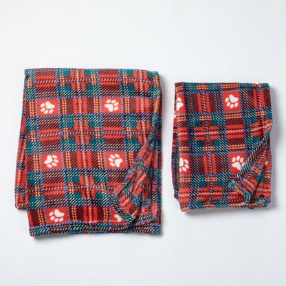 Two folded pet blankets in red plaid fabric with white paw print motifs, displayed on a light gray background.
