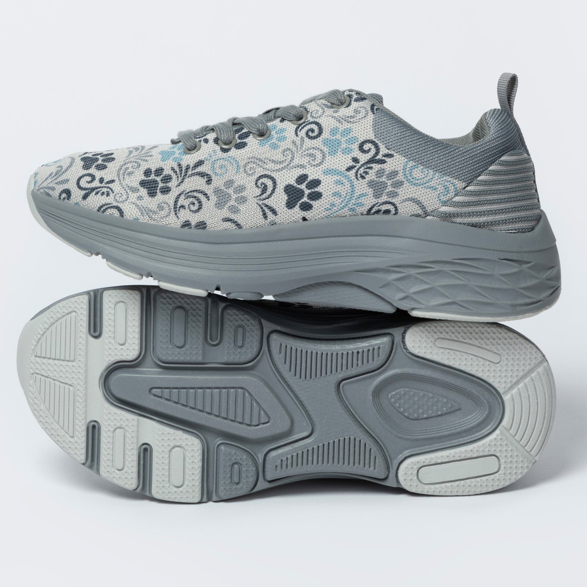Gray sneakers with a deep textured outsole, featuring a paw print and floral pattern, on a white background.