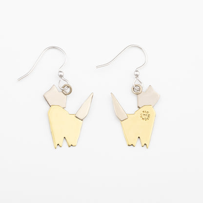 The backs of a pair of brass and silver cat -shaped earrings on a white background