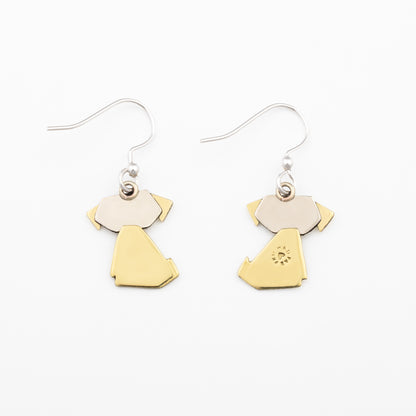 The backs of a pair of earrings with brass and silver dog-shaped pendants on a white background