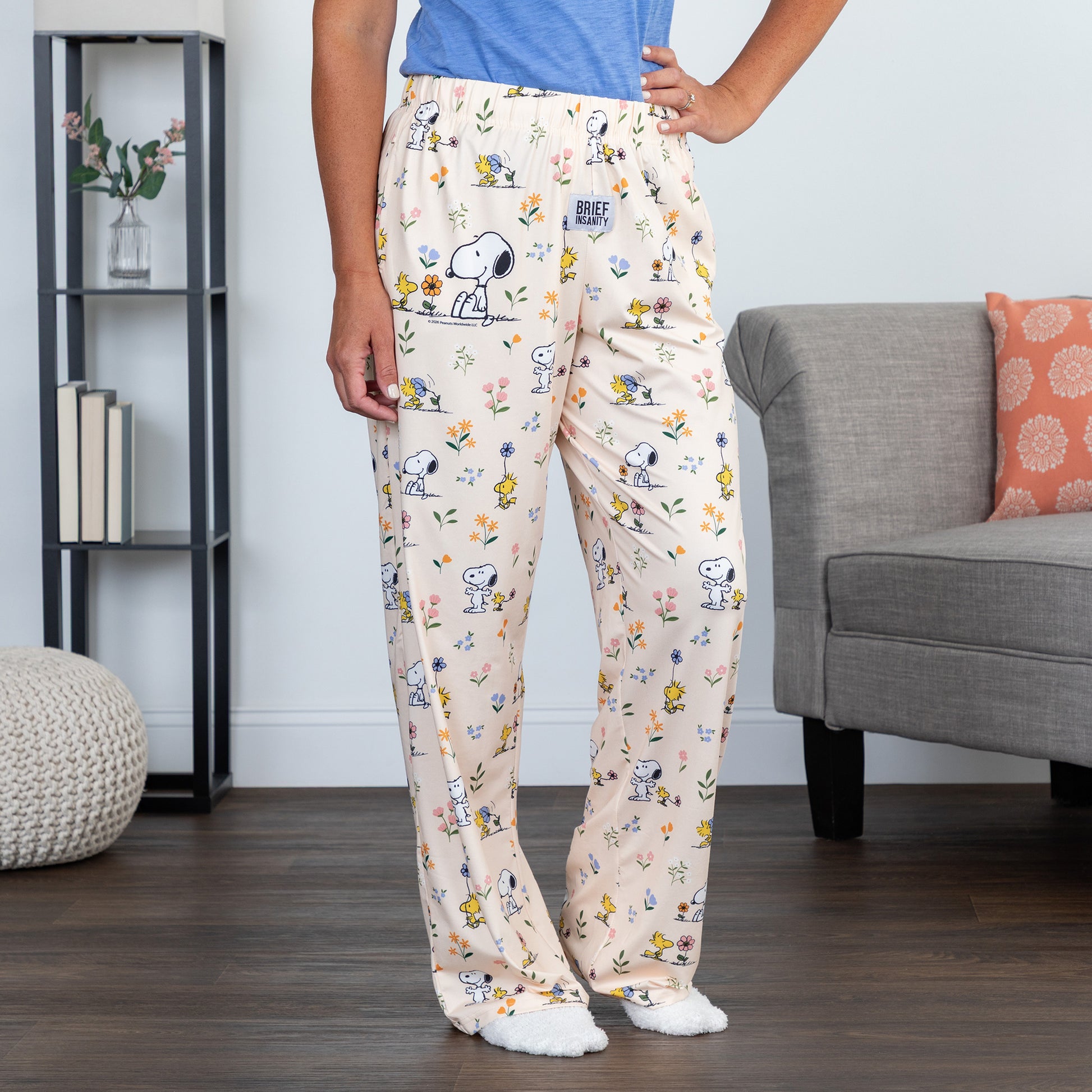 Person wearing Snoopy pajama pants in a living room setting