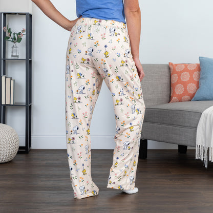 Person wearing pajama pants with a snoopy and woodstock pattern in a living room.