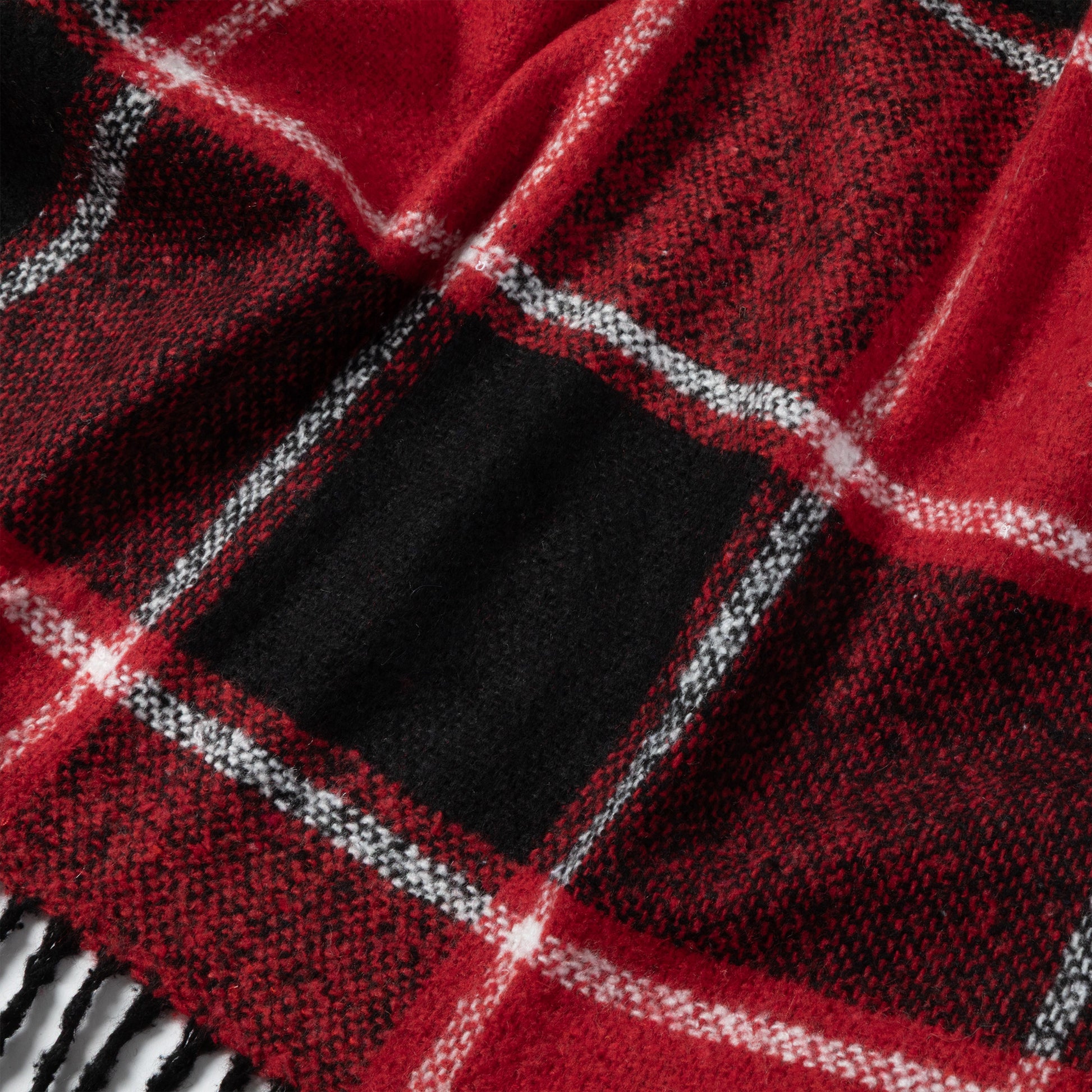 Close-up of a cozy red and black plaid scarf with white accents.