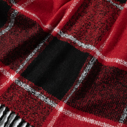 Close-up of a cozy red and black plaid scarf with white accents.