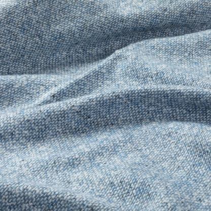 Light blue textured fabric with subtle woven patterns and gentle wrinkles.