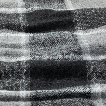 A close-up of a black and white plaid woven blanket, showing the detailed weave and pattern.
