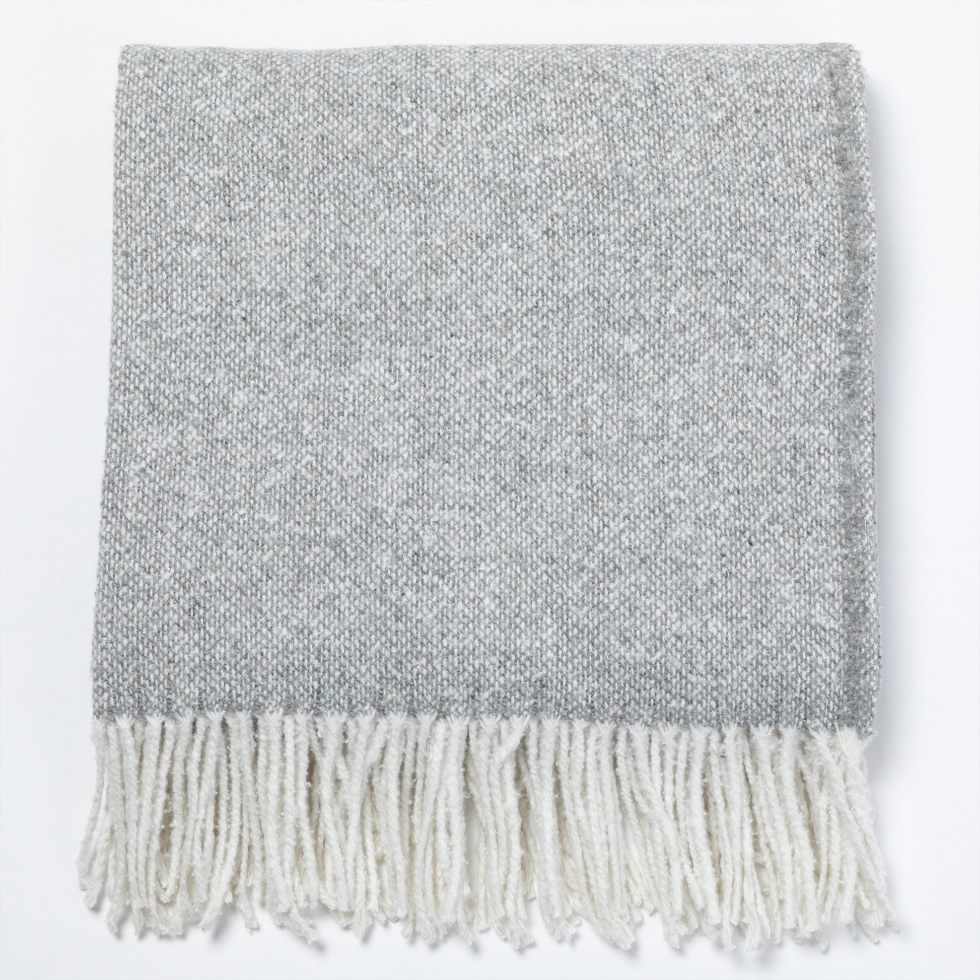 Gray woven throw blanket with white fringes, perfect for cozying up.