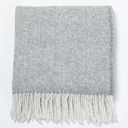 Gray woven throw blanket with white fringes, perfect for cozying up.