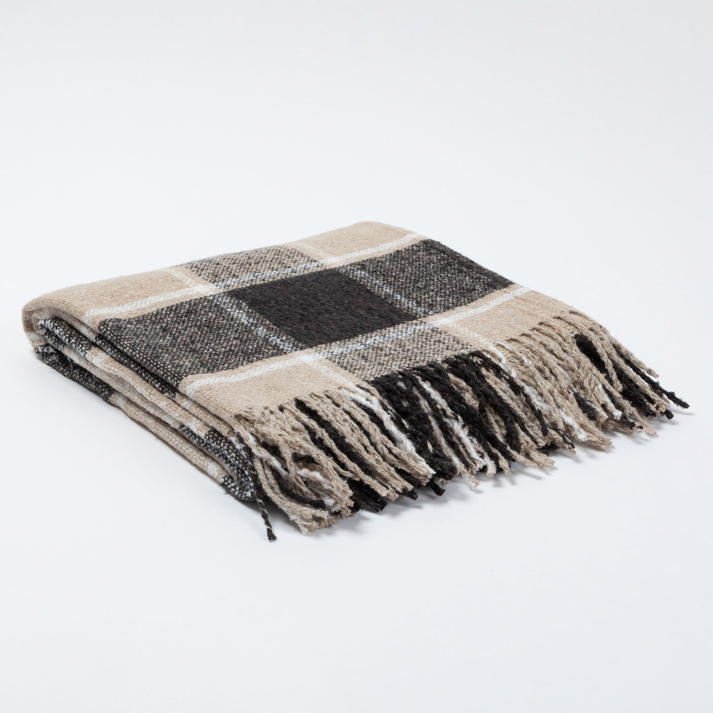 A folded plaid throw blanket with fringed edges, featuring a pattern of beige, black, and white, set against a plain white background.