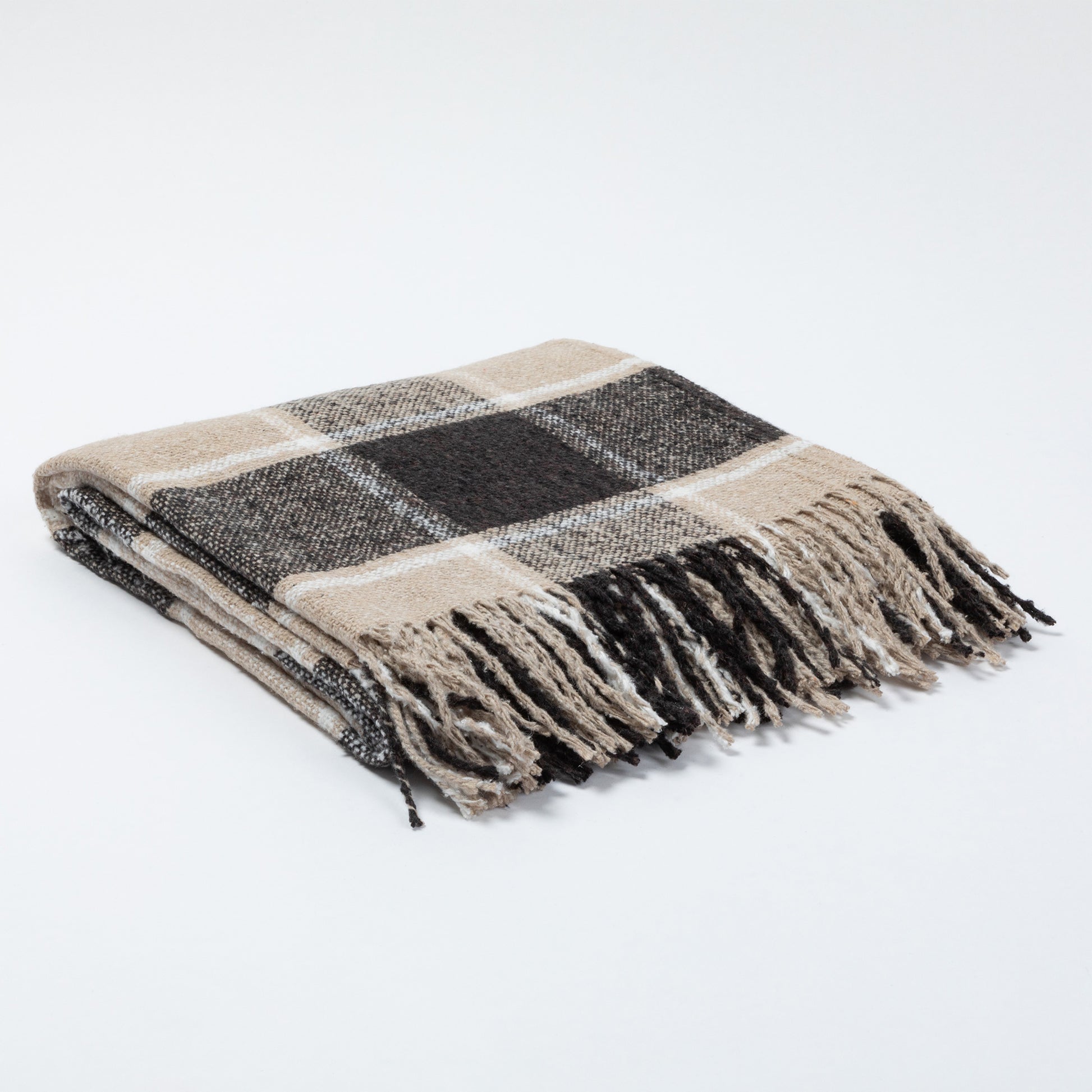 A folded plaid throw blanket with fringed edges, featuring a pattern of beige, black, and white, set against a plain white background.