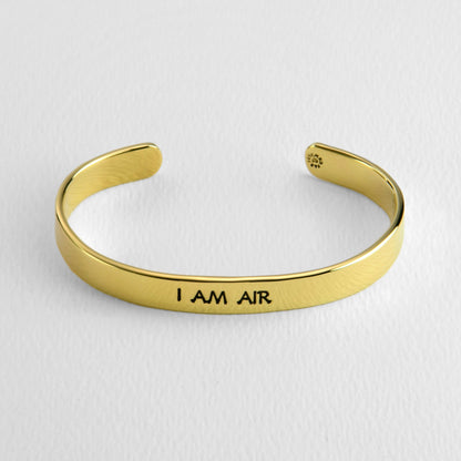 Brass bracelet with 'I AM AIR' engraving on a white background