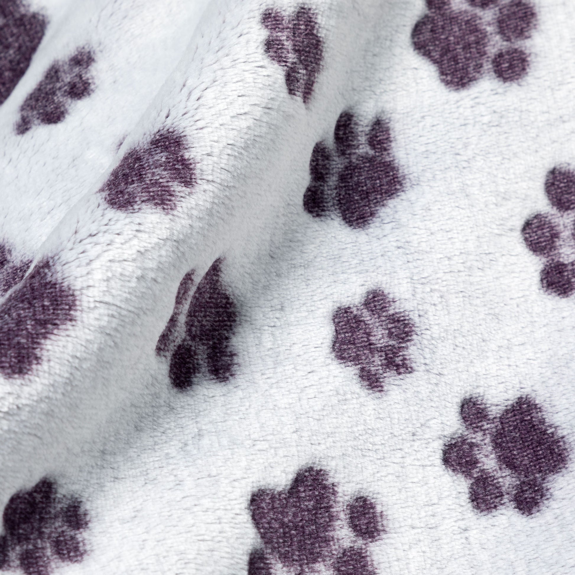 Close-up of fabric with purple paw prints on light gray fleece.