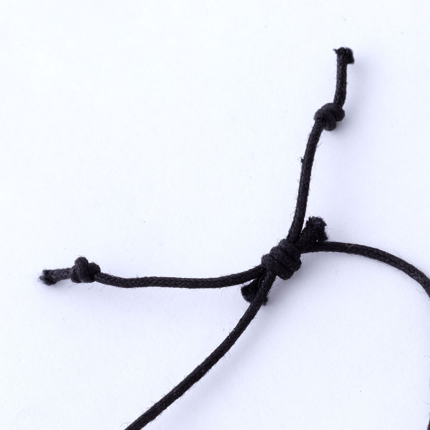 Close-up of a black cord with a knot on a white background