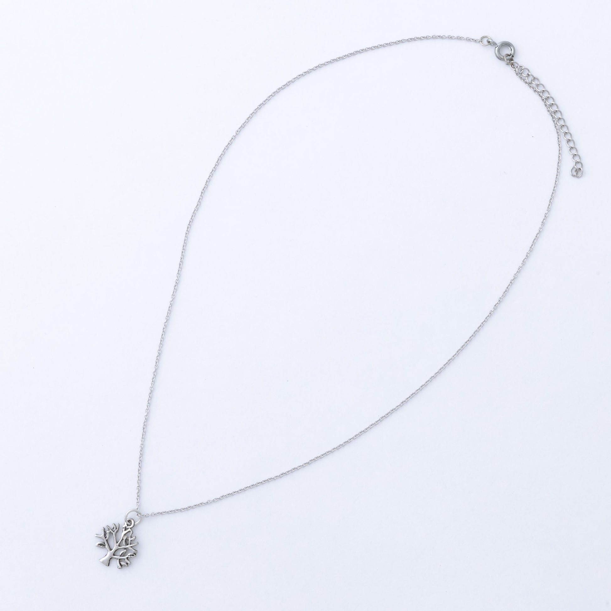 Silver necklace with a tree of life pendant on a light gray background