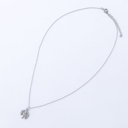 Silver necklace with a tree of life pendant on a light gray background