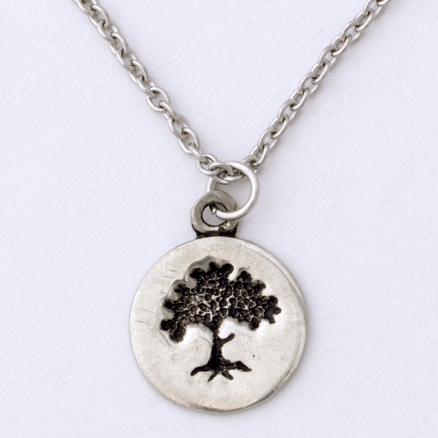 Silver necklace with a tree pendant on a white background