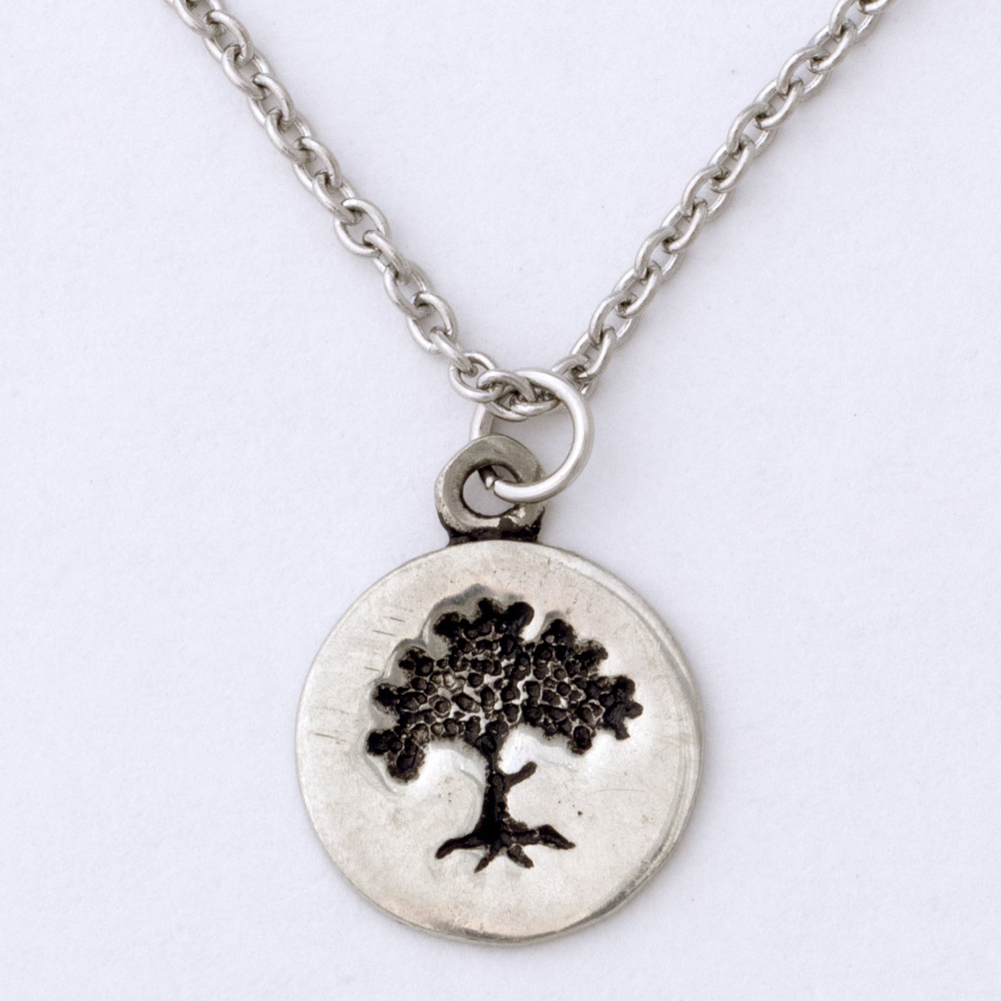 Silver necklace with a tree pendant on a white background