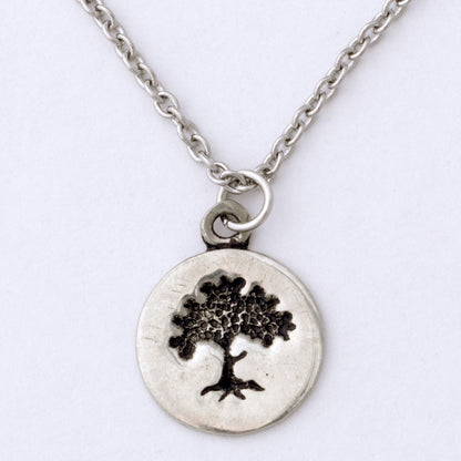 Silver necklace with a tree pendant on a white background