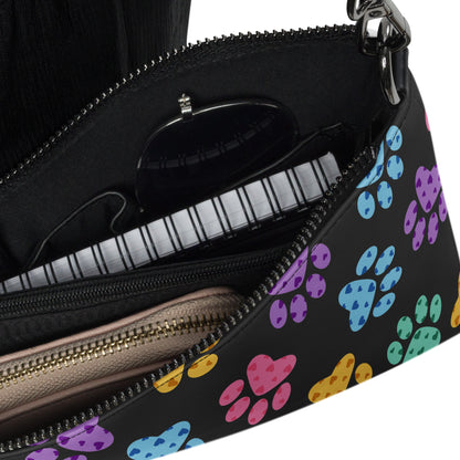 Close up of a Black handbag with colorful paw print pattern on a white background