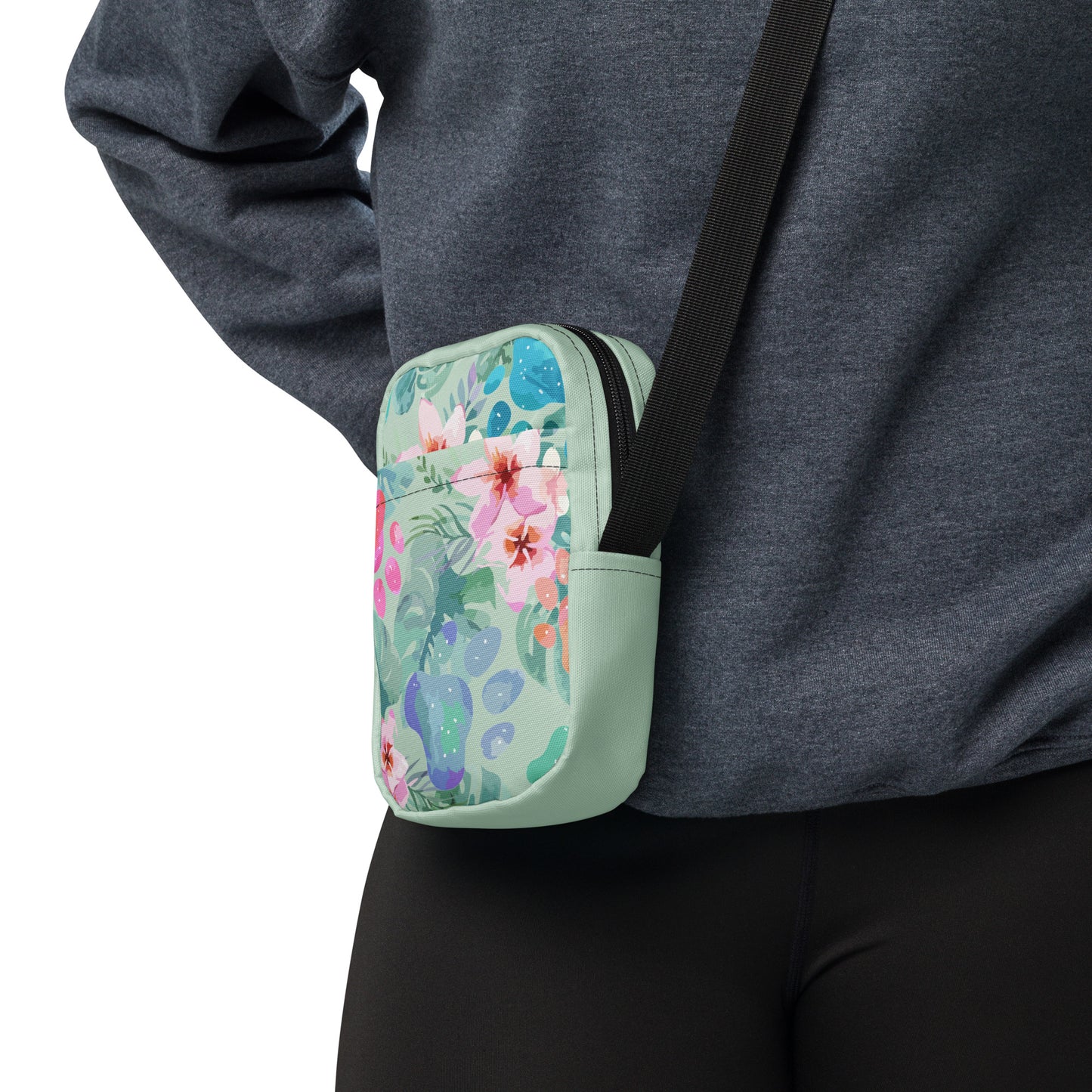 Floral-patterned crossbody bag worn over a person's shoulder on a white background