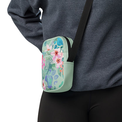 Floral-patterned crossbody bag worn over a person's shoulder on a white background