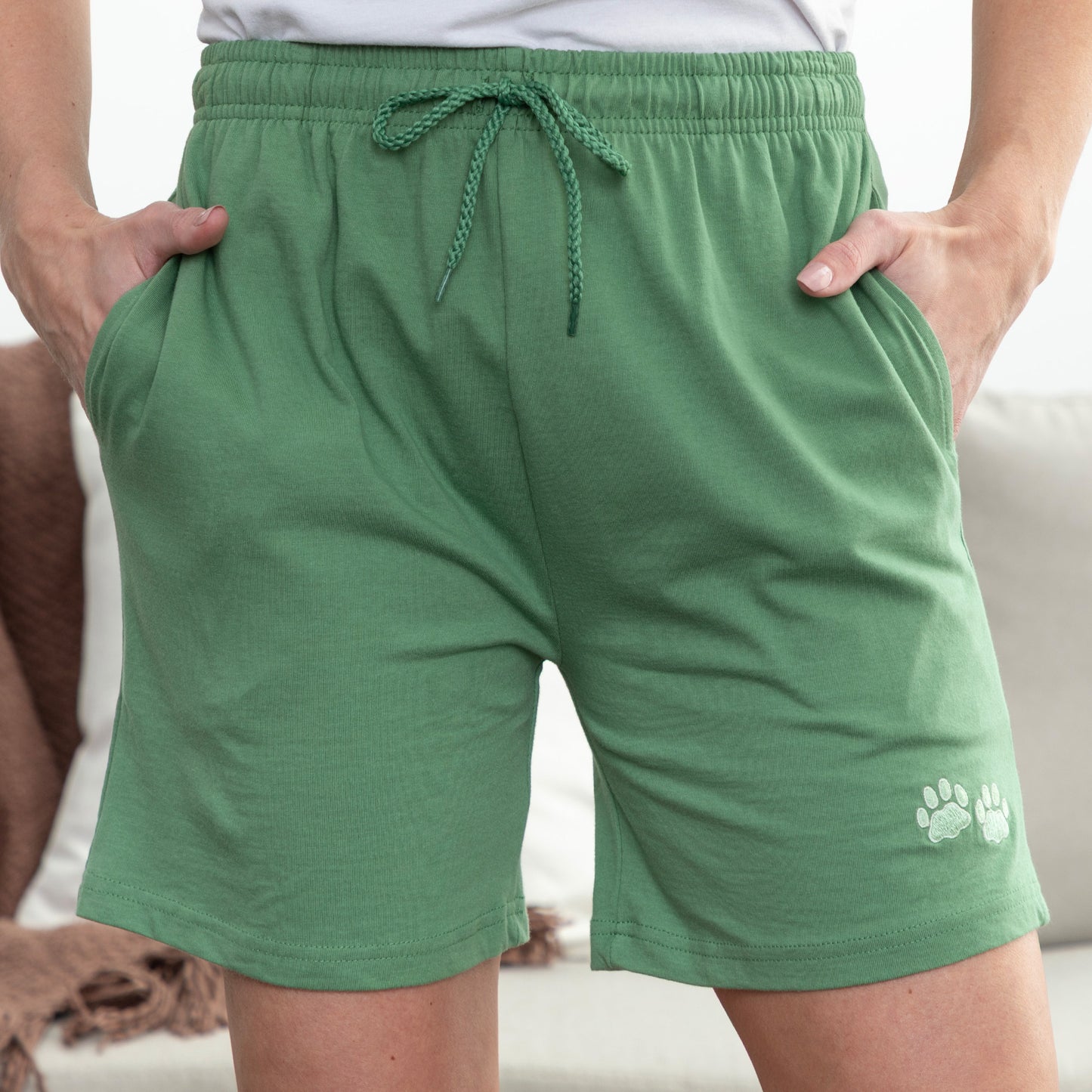 Green shorts with a paw print design on a neutral background