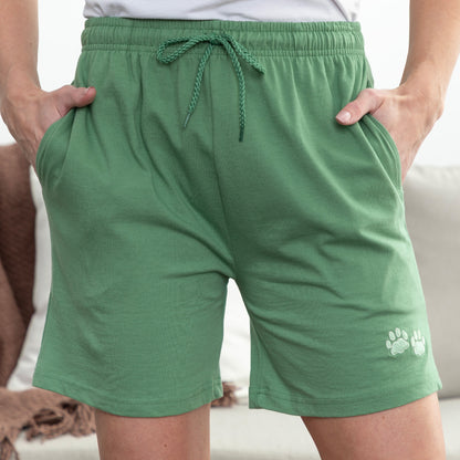 Green shorts with a paw print design on a neutral background
