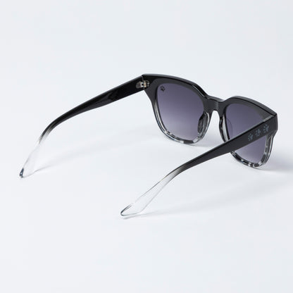 Black sunglasses with gradient lenses on a light gray background