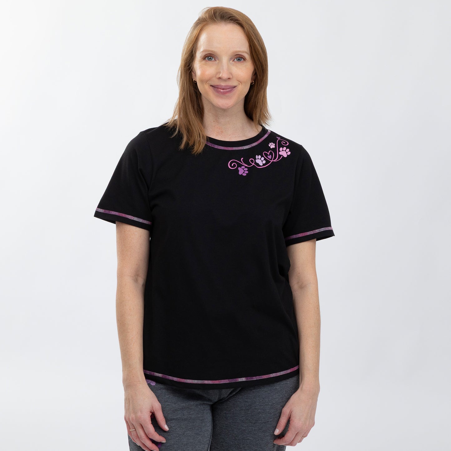 Woman wearing a black t-shirt with purple trim and floral design on a white background