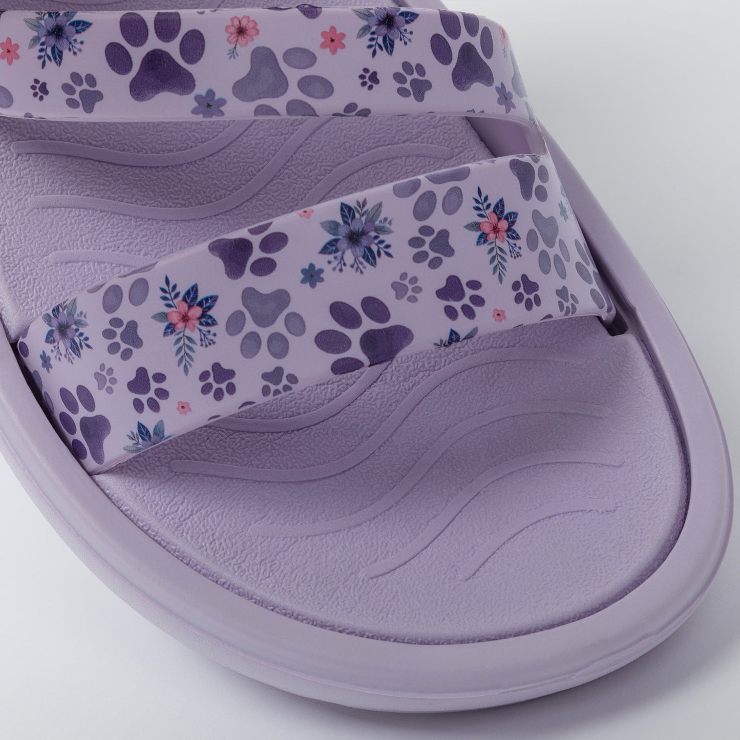 Purple sandal with floral paw print strap on a white background