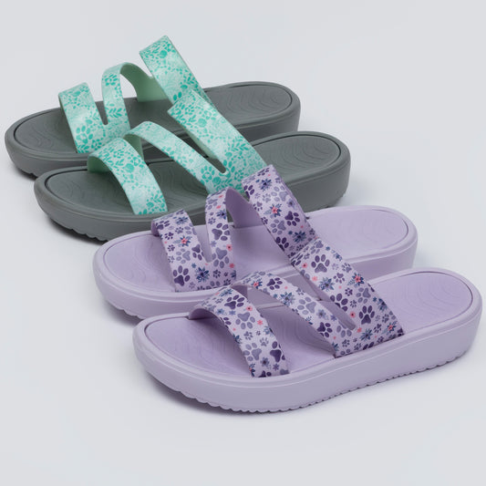 Two pairs of sandals, one gray with floral straps and one purple with paw print straps, on a light gray background.