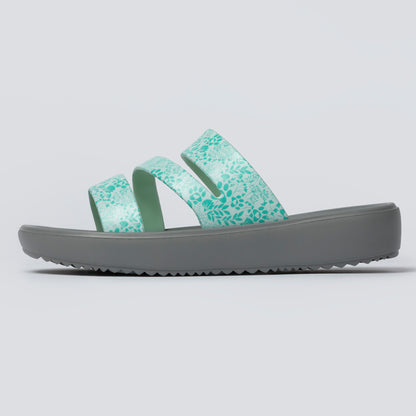 Green slide sandal with gray sole on a light gray background