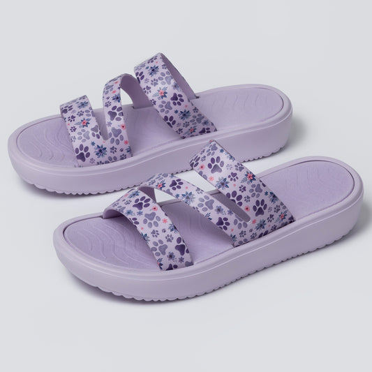 Pair of purple sandals with floral pattern on a light gray background