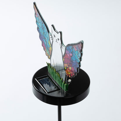 Cat silhouette with mosaic angel wings on a garden stake with a small solar panel, against a white background.