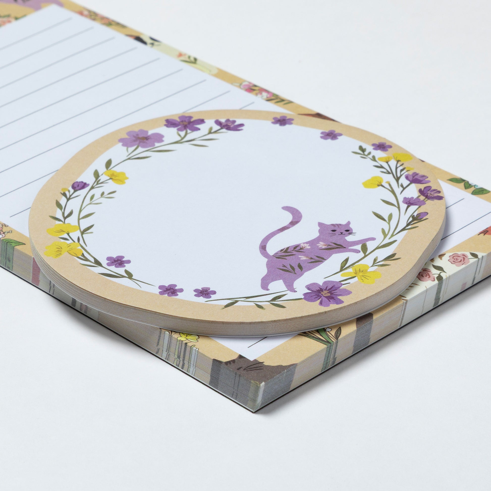 Notepad with a purple cat illustration on a floral border