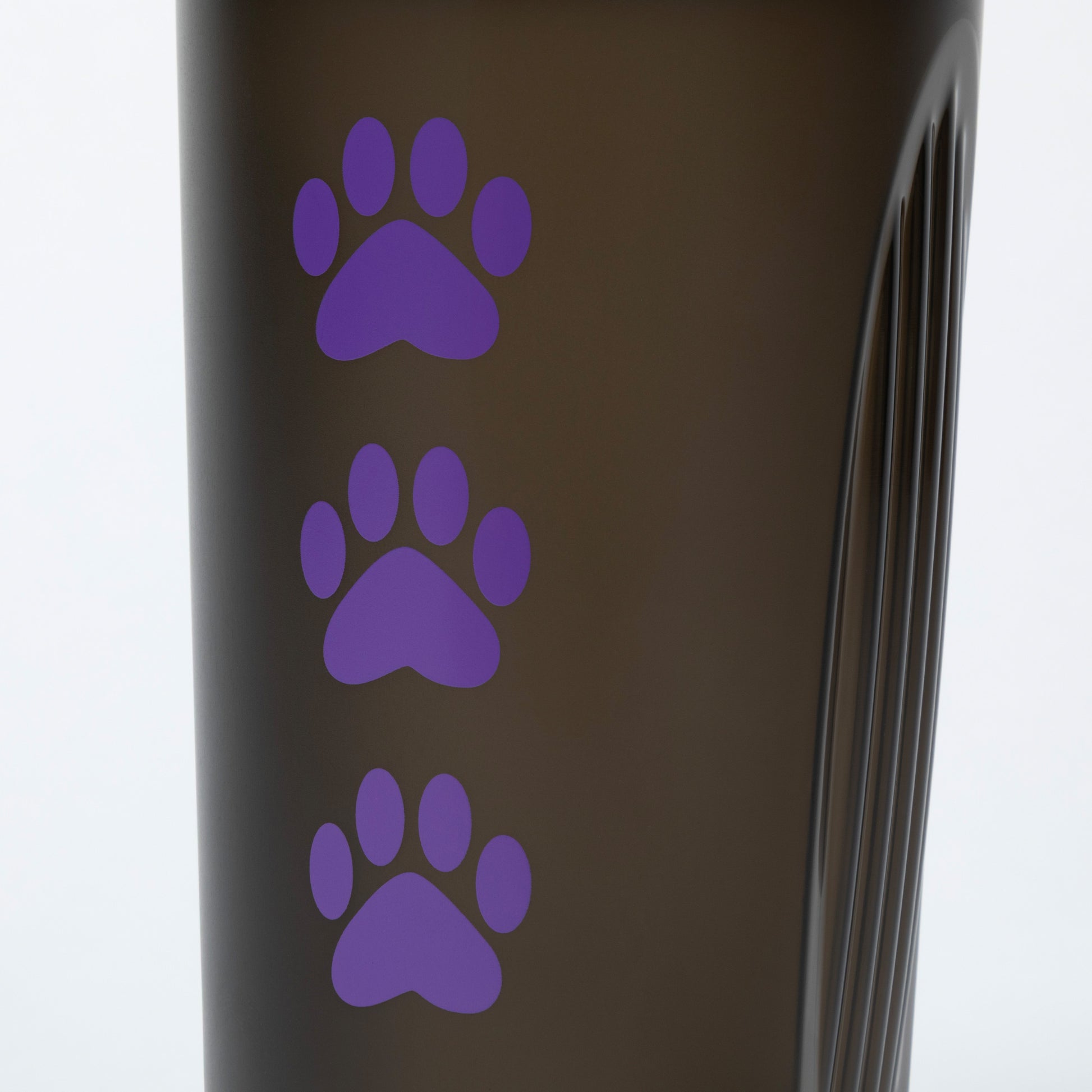 Black tumbler with purple paw prints on a white background
