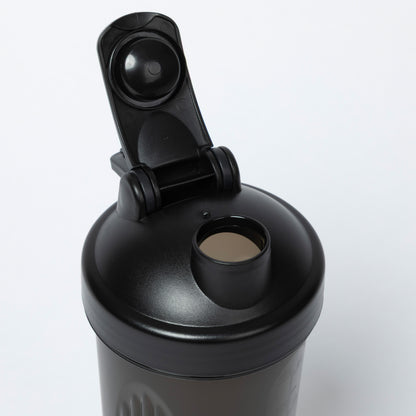Black shaker bottle with a clip on lid against a white background
