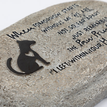 Close up of polyresin garden stone with a dog silhouette and engraved text on a white background